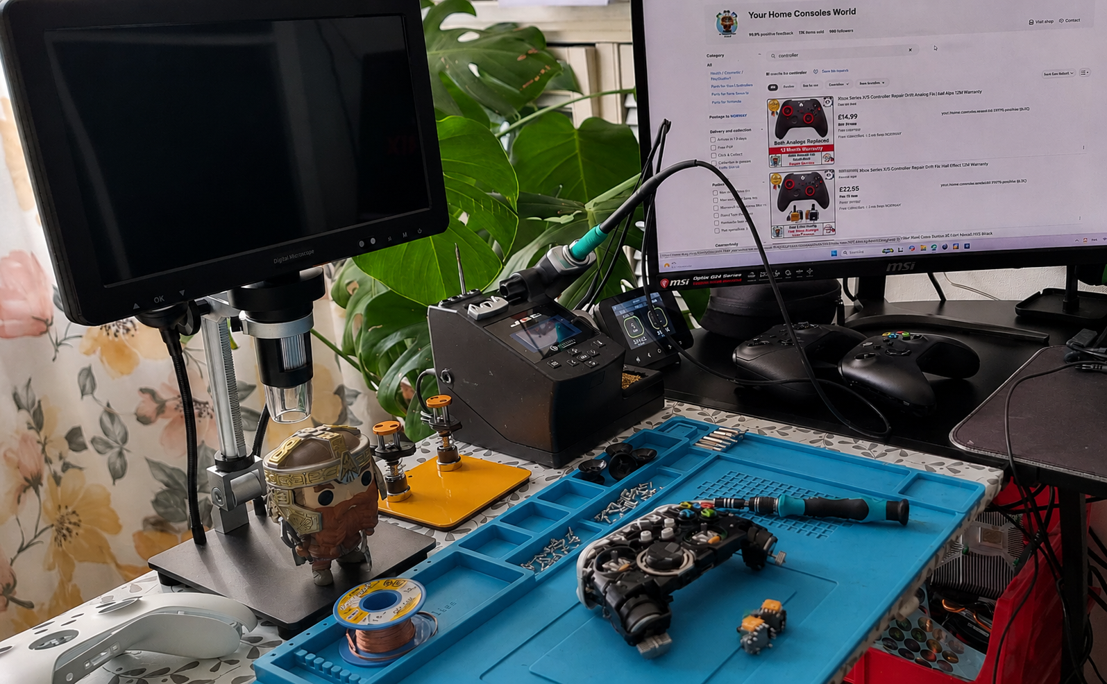 Workstation with electronic components, tools, and computer monitors on a desk.